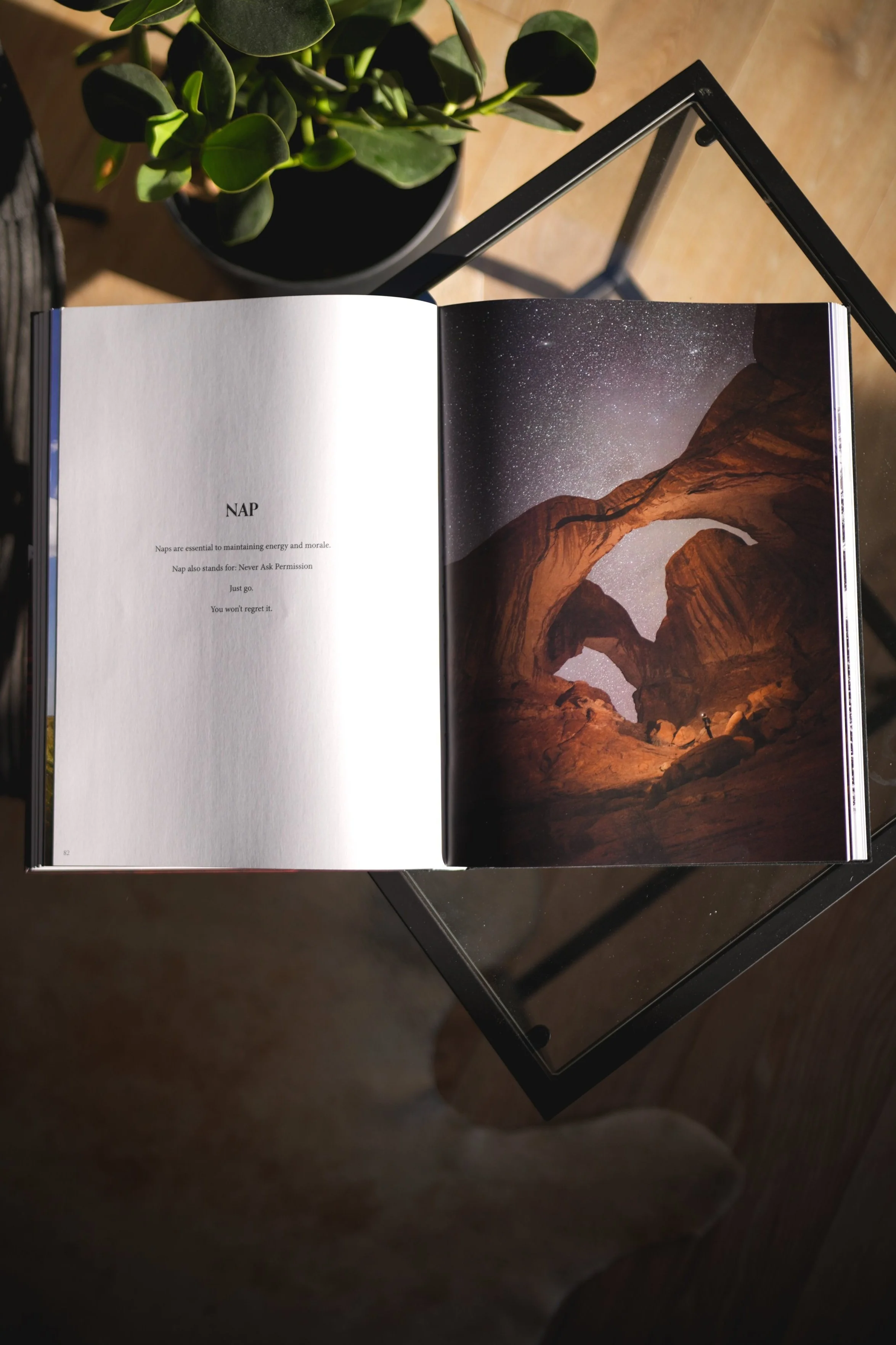 An open printed book on a glass table, a starry double arch across its right page